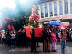 Masyarakat Antusias di Tengah Hujan Deras Untuk Merebutkan Kue Keranjang